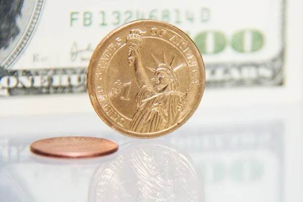 Monedas de un centavo y dólar contra cien billetes — Foto de Stock
