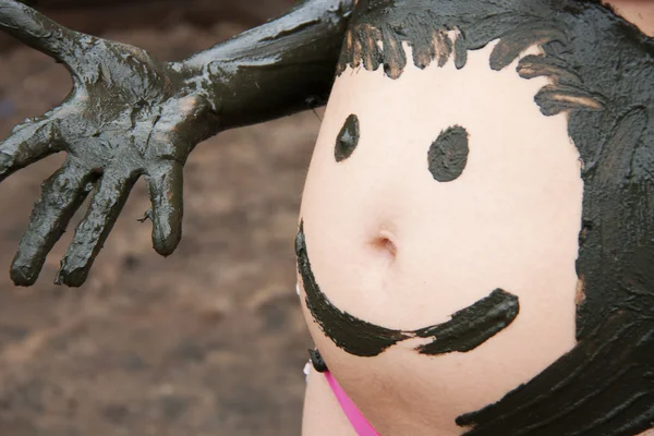 stock image Mud smiley on pregnant woman belly