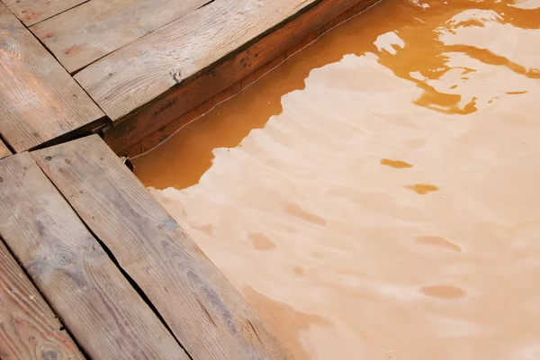 Деревянная платформа и термальная вода в горячем пруду — стоковое фото