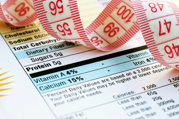 Nutrition facts and measure tape — Stock Photo, Image