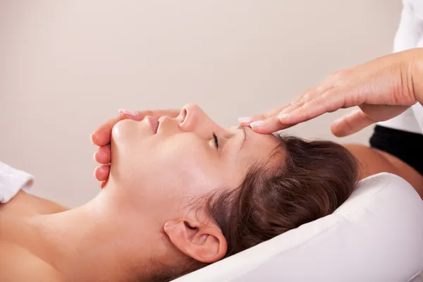 Giovane bella donna ottenere massaggio facciale — Foto Stock