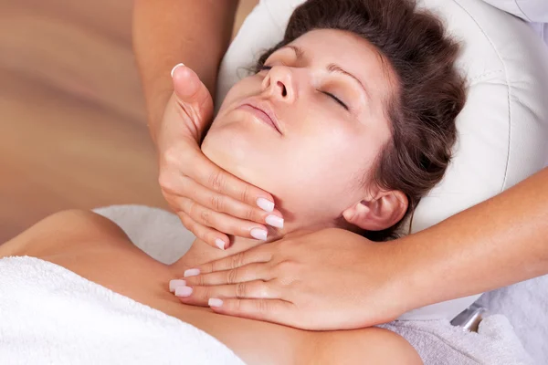 Jovem bela mulher recebendo massagem facial — Fotografia de Stock