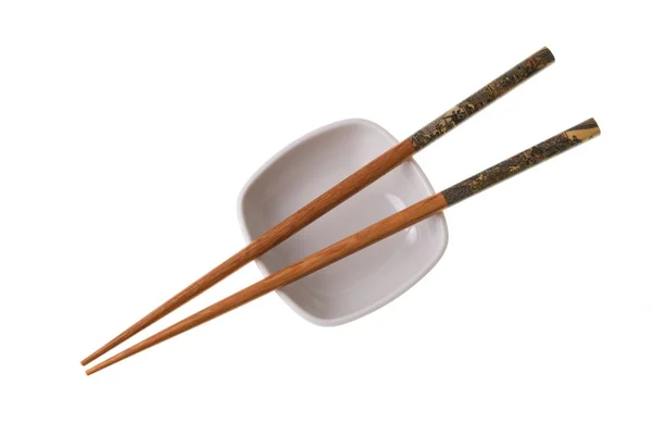 Wooden chopsticks on white saucer — Stock Photo, Image