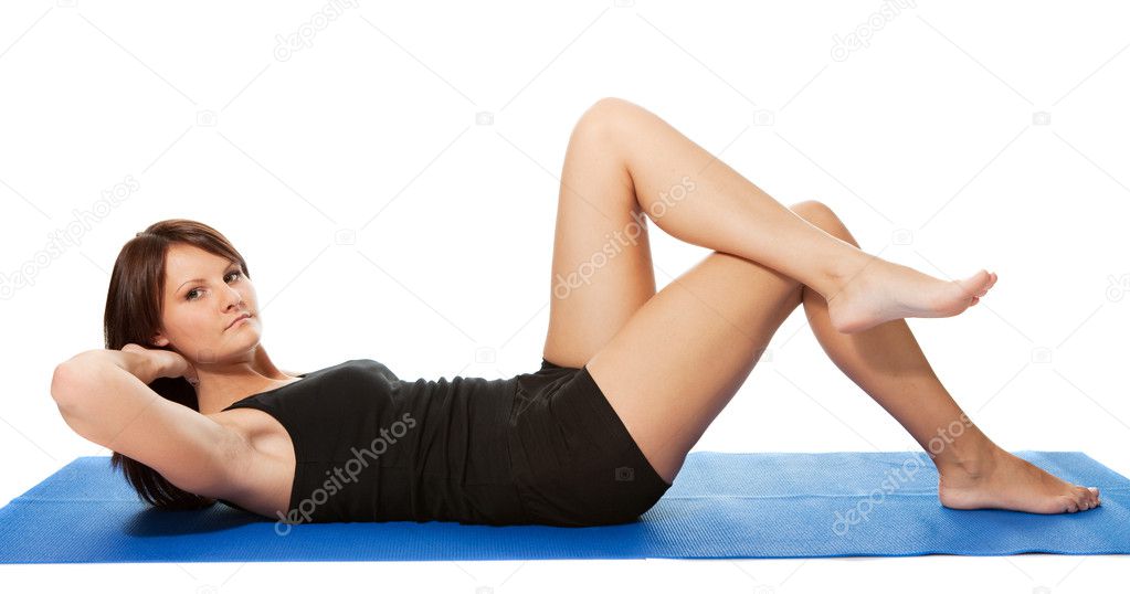 Young women doing crunches on the fitness mat