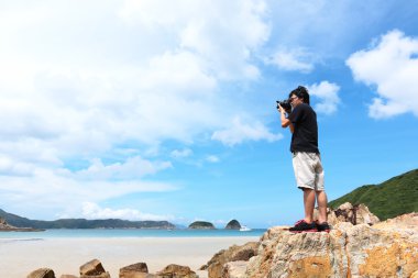 Photographer taking photo on beach clipart