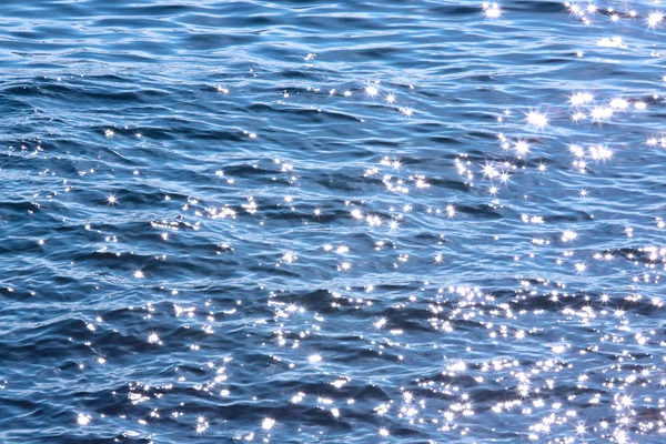 Luci scintillanti su acqua blu — Foto Stock