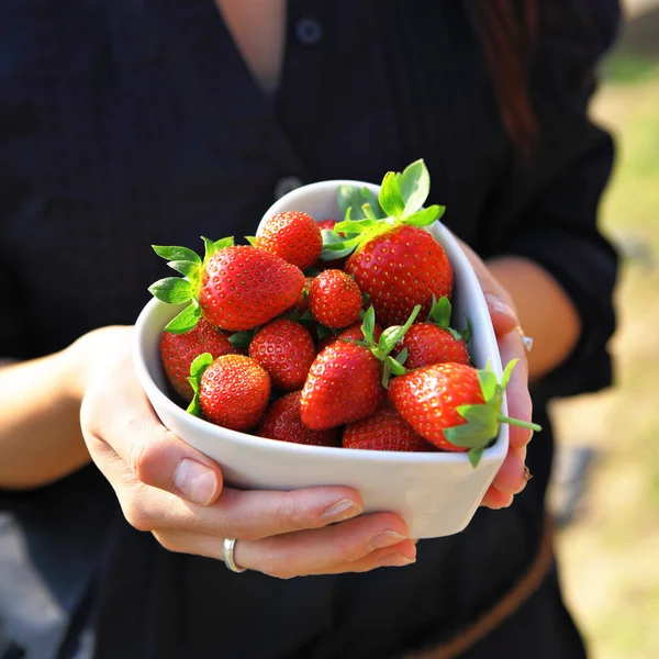 Strawberry in heart shape bowl with hand — Stock Photo, Image