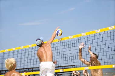 Letonya, Jurmala, Plaj voleybolu müsabakası plajda dinlenmek arasında. Şebeke üzerindeki darbe bloğu.