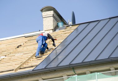 The roofer behind work on repair a roof