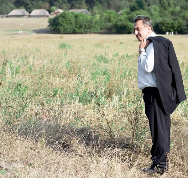 Biznesmen stoi w polu — Zdjęcie stockowe