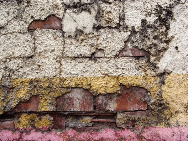 Intonaco rotto di tre colori su un muro di mattoni — Foto Stock
