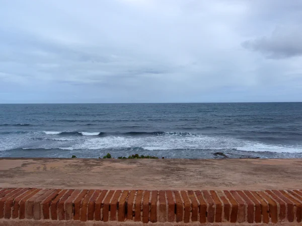 Viejo muro y olas que se estrellan en el océano — Foto de Stock