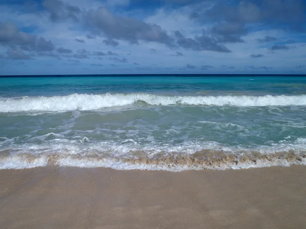 Dramatické vlna smetla jako druhý přichází dopředu na pláži — Stock fotografie