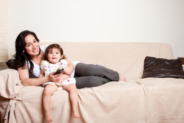 Mother and daughter watching TV clipart