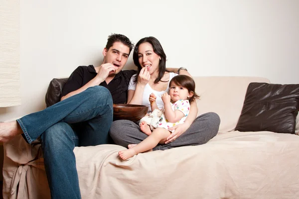沙发沙发上吃零食的幸福家庭 — 图库照片