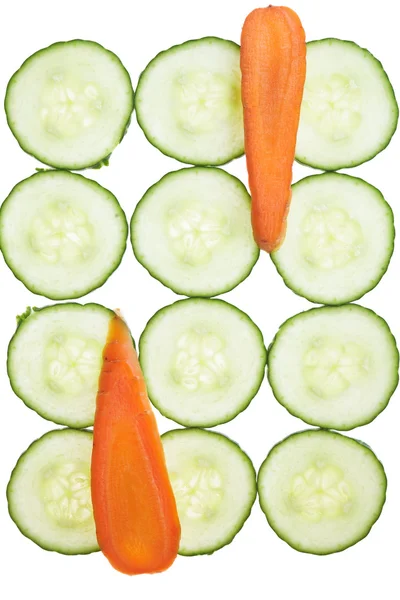 Wortel en komkommer plakjes arrranged in een patroon. — Stockfoto