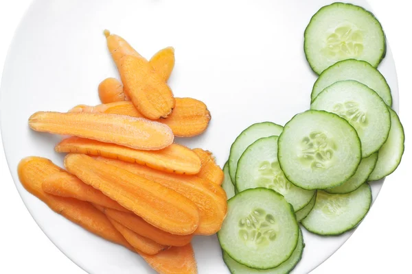 Fette di carota e cetriolo in piatto bianco . Foto Stock
