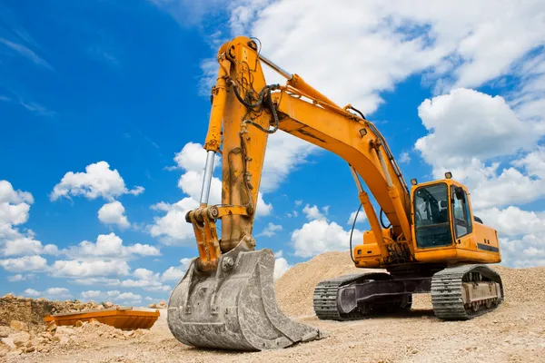Excavadora amarilla en el sitio de construcción — Foto de Stock