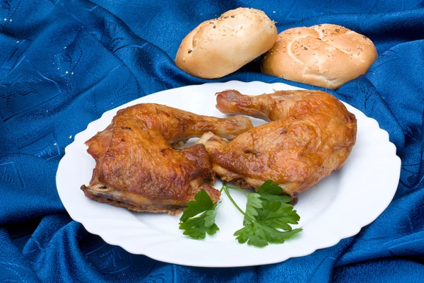 Jambes de poulet disposées avec des pains — Photo