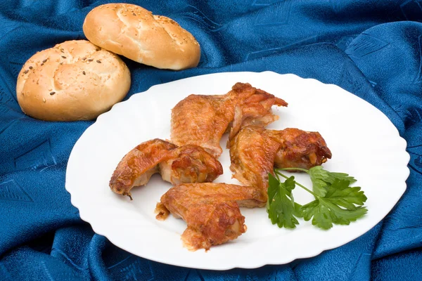 Chicken wings arranged with loafs of bread — Stock Photo, Image
