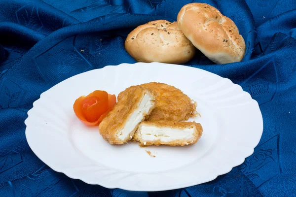 Um prato de queijo frito apresentado com loafs de pão — Fotografia de Stock