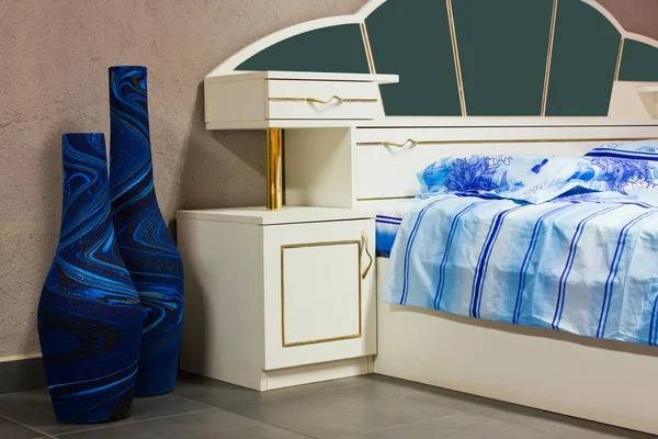 Quarto, cama com lençóis e mesas noturnas — Fotografia de Stock