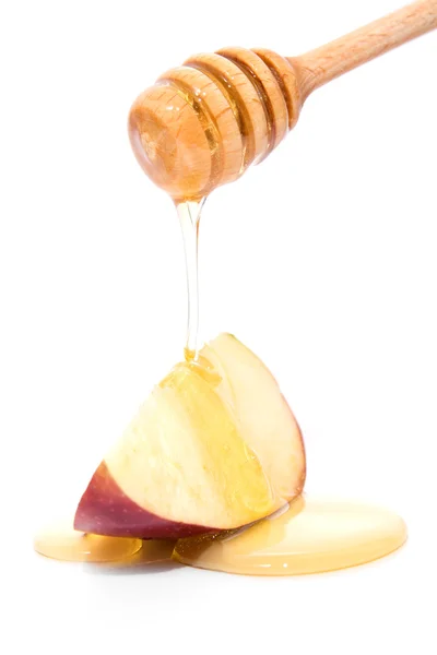 Palillo con miel goteando en manzana roja aislada en blanco — Foto de Stock