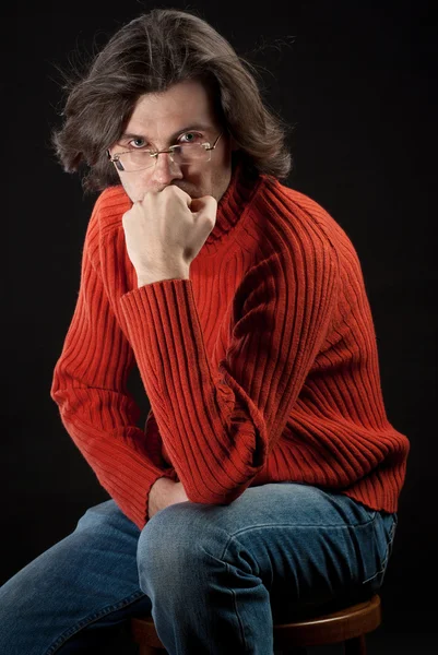 Uomo in maglione rosso seduto sulla sedia — Foto Stock