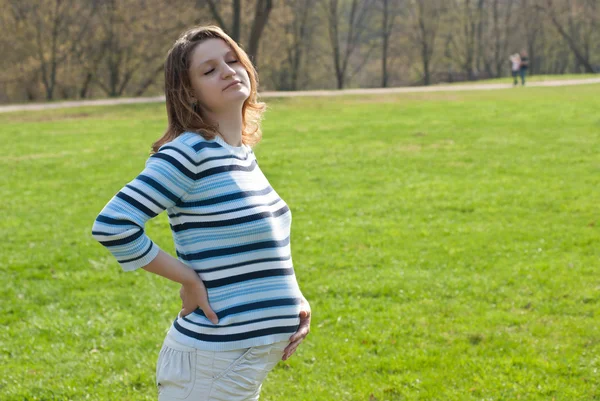 Hamile kadın çayır üzerinde rahatlatıcı — Stok fotoğraf