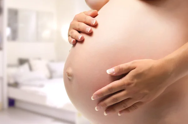 Красивый беременный живот в руках женщины . — стоковое фото