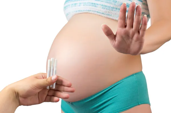 Pregnant belly with cigarettes. — Stock Photo, Image