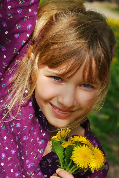 Jong meisje met paardebloemen — Stockfoto