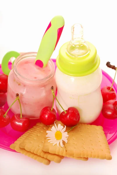 Cherry yogurt and bottle of milk for baby — Stock Photo, Image