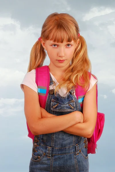 Angry schoolgirl against cloudy sky — Stock Photo, Image