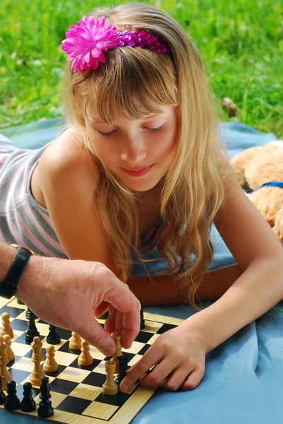Молодая девушка играет в шахматы снаружи — стоковое фото