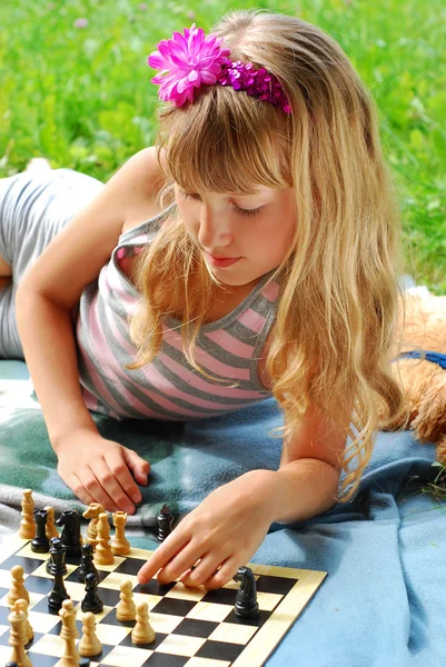 Молодая девушка играет в шахматы снаружи — стоковое фото