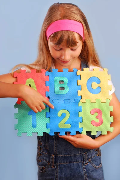 Colegiala con rompecabezas de alfabeto — Foto de Stock
