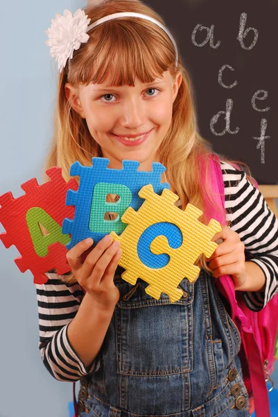 Školačka držící dopisy puzzle — Stock fotografie