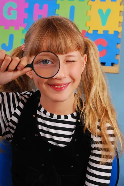 Schoolgirl with magnifying glass — Stock Photo, Image
