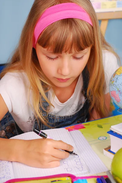 Schoolmeisje leren om brieven te schrijven — Stockfoto