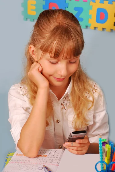 Schoolmeisje met behulp van mobiele telefoon tijdens de les — Stockfoto