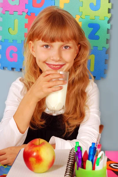 Schoolgirl with glass of milk and an apple — Stok fotoğraf
