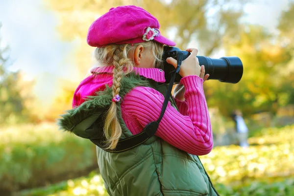 Young girl taking photos in autumn park — Stock Photo, Image
