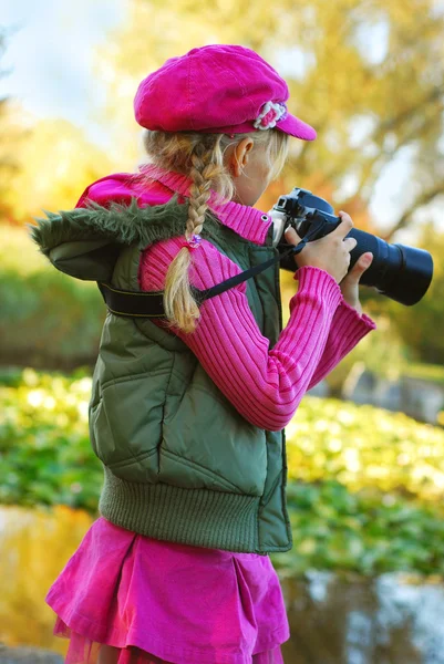 Chica joven tomando fotos en el parque de otoño — Foto de Stock