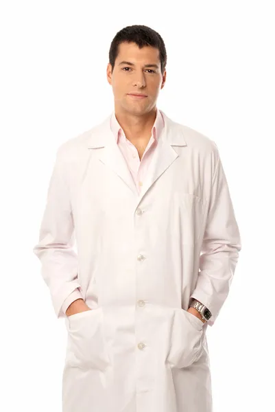 Médico sorriso mãos em bolsos isolados no fundo branco — Fotografia de Stock