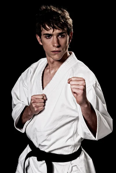 Karate muž bojovník mladých vysoký kontrast na černém pozadí. — Stock fotografie