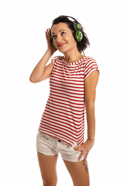 Jovem mulher ouvindo música com fones de ouvido em pé sobre fundo branco — Fotografia de Stock