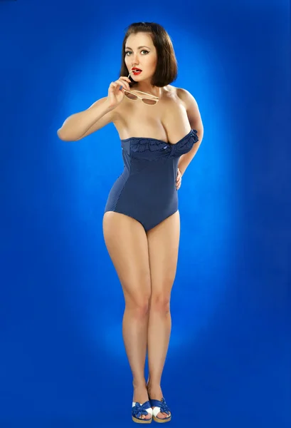La fille en maillot de bain sur fond bleu foncé — Photo