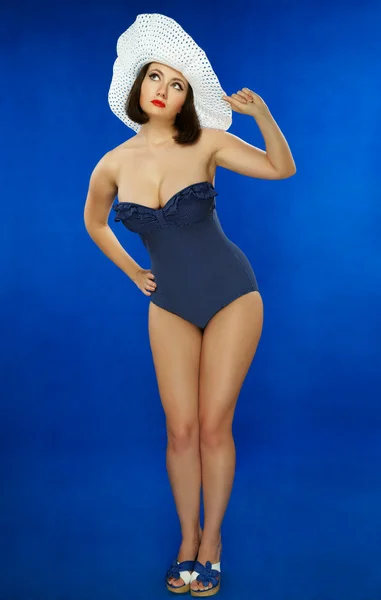 Dziewczyna w kostiumie kąpielowym na ciemnym niebieskim tle — Zdjęcie stockowe