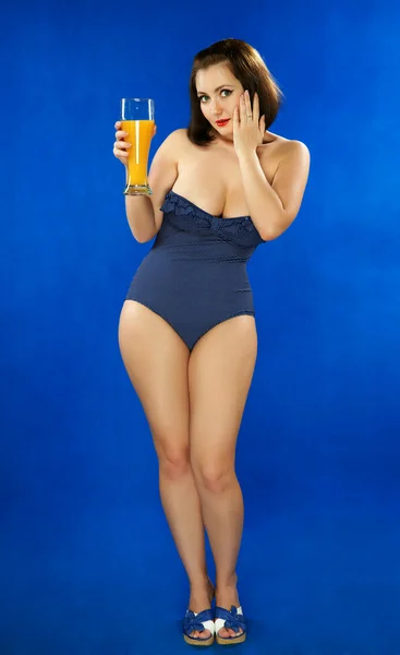La chica en un traje de baño con jugo de naranja —  Fotos de Stock